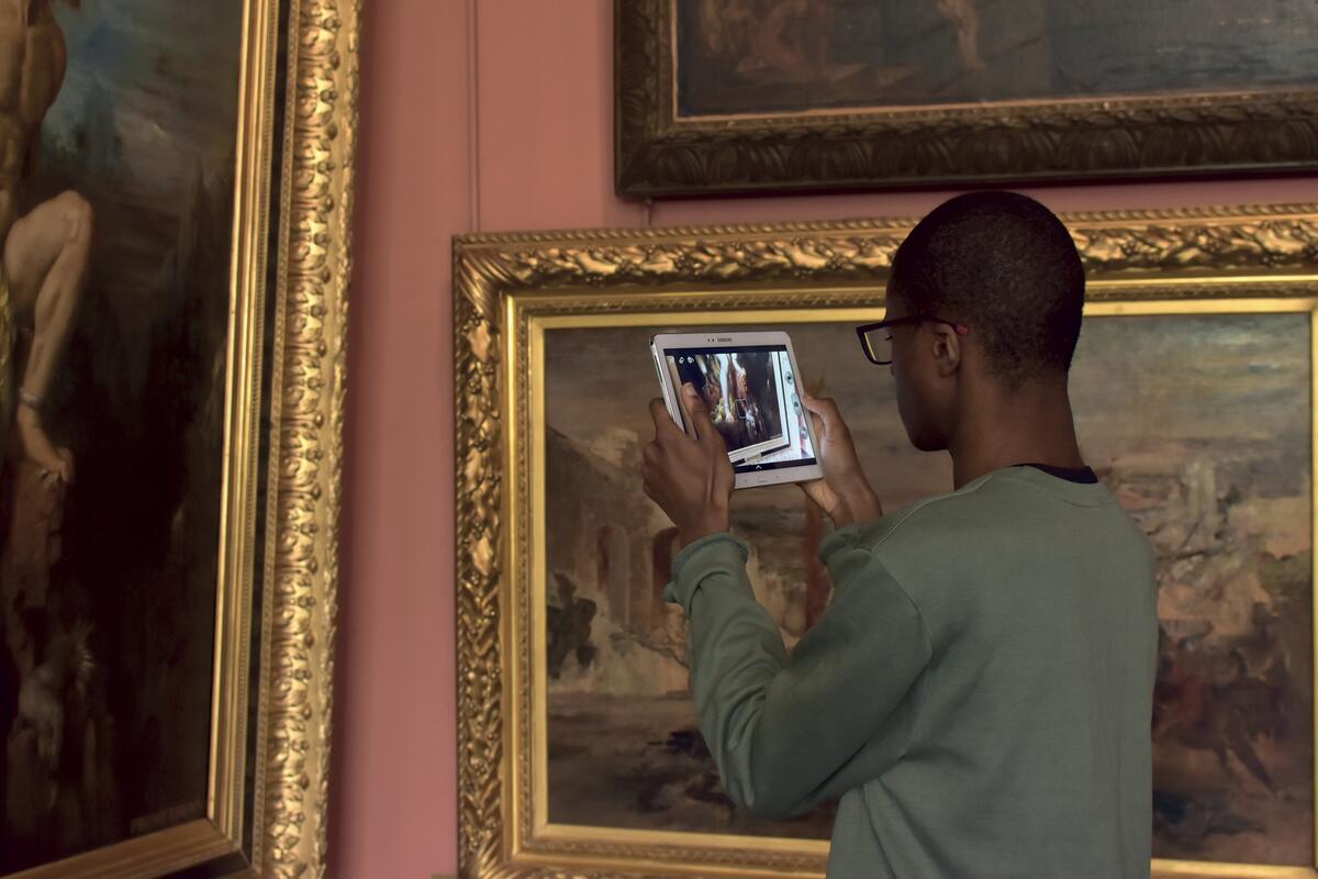 Un jeune homme prend une photo au musée
