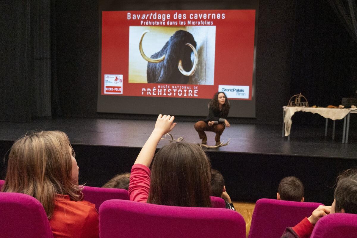 Des enfants assis dans un auditorium devant une présentation