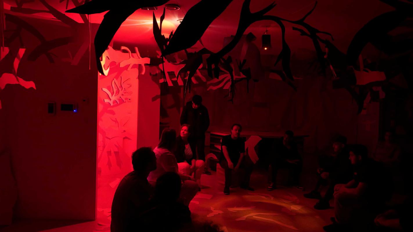 Photo d'une restitution d'exposition avec des découpages dans une lumière rouge