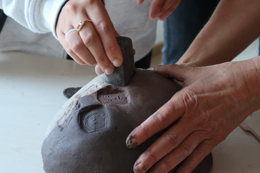 Des mains jouant avec de l'argile et des tampons